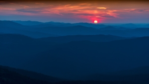 The sun is setting over a mountain range