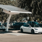 Electric car parked at a solar charging station outdoors, highlighting renewable energy and innovation.