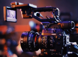 Close-up of a professional video camera setup indoors, capturing high-quality footage.