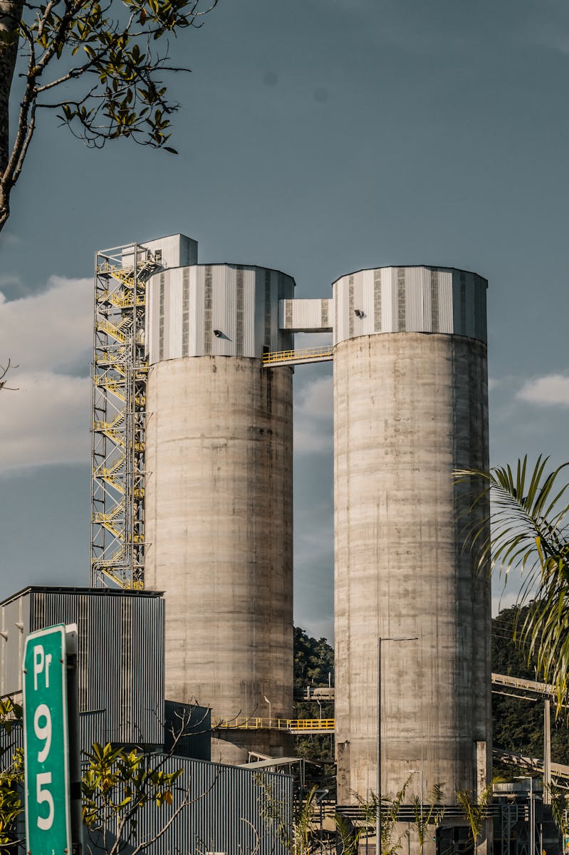 Starting a Cement Manufacturing Business in Nigeria Vertical shot of silos at a cement plant in Colombia with industrial landscape.