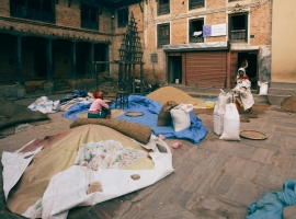 Scene of people working with grain bags in a traditional brick courtyard.