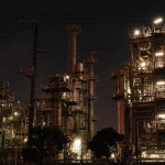 Night view of a brightly lit industrial facility showcasing intricate steel structures and machinery.