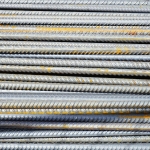 Step-by-Step Guide to Setting Up a Mini Rebar Steel Rolling Mill in Nigeria Close-up of stacked rusty steel reinforcing bars used in construction.