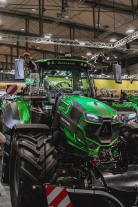Front view of a Deutz-Fahr tractor showcased at an indoor agricultural machinery exhibition.