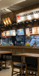 Cozy interior of Japanese restaurant with chefs preparing meals.