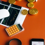 Stock market and financial analysis setup with calculator, graphs, and gold coins.