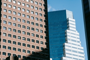 Low-angle view of modern skyscrapers against a clear blue sky.